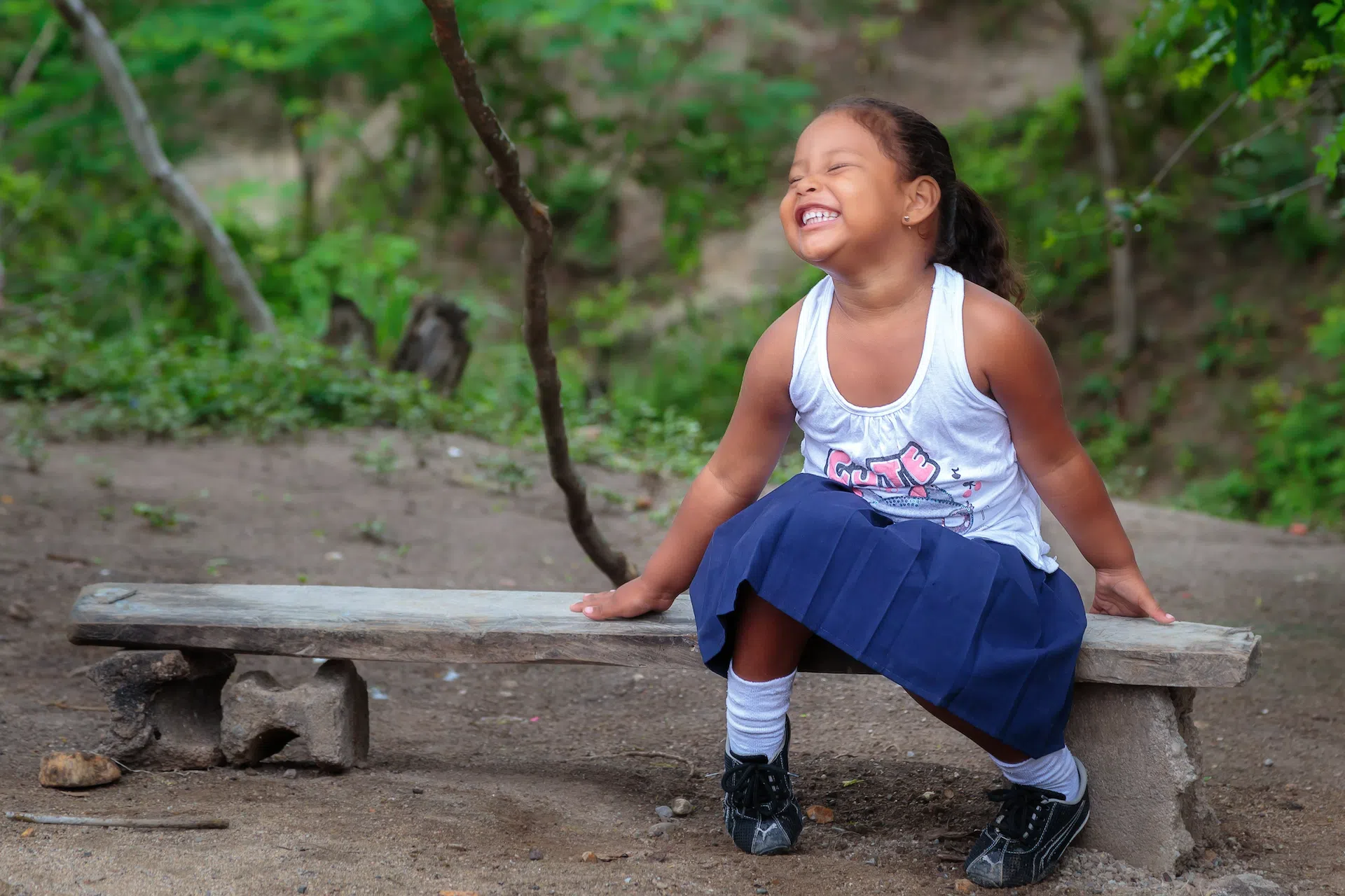 Child smiles on bench