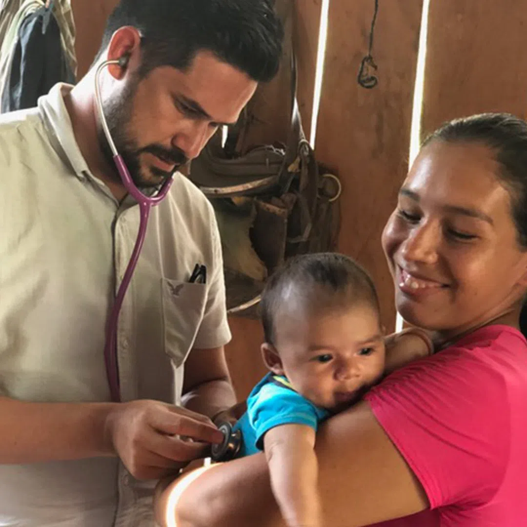 Volunteer performing checkup on infant